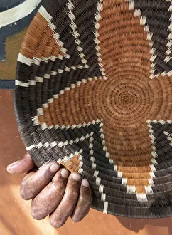 A traditional basket weaver with basket in Maun, Botswana A traditional basket weaver with basket in Maun, Botswana