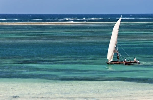 A traditional outrigger canoe sails close to the shore at Diani Beach A traditional outrigger canoe sails close to the shore at Diani Beach