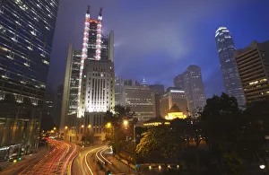 Traffic passing along Queens Road Central at dusk with HSBC building in background Traffic passing along Queens Road Central at dusk with HSBC building in background