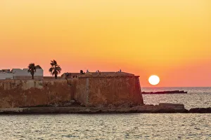 Trapani, Sicily. Seascape of the Ligny tower with the sun setting in the sea Trapani, Sicily. Seascape of the Ligny tower with the sun setting in the sea