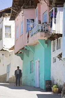 Turkey, Eastern Turkey, Malatya, Gunduzbey Village, Man walking along street past Turkey, Eastern Turkey, Malatya, Gunduzbey Village, Man walking along street past