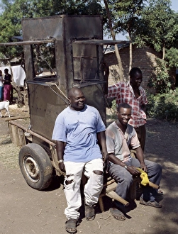An unfinished mobile phone kiosk is carried on a mkokoteni An unfinished mobile phone kiosk is carried on a mkokoteni