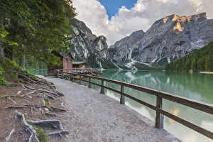 A view of Croda del Becco and footpath and house of boats from Braies lake at sunset A view of Croda del Becco and footpath and house of boats from Braies lake at sunset