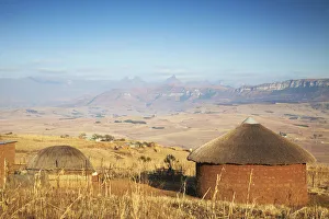 Village huts with Cathedral Peak in background, Ukhahlamba-Drakensberg Park, KwaZulu-Natal Village huts with Cathedral Peak in background, Ukhahlamba-Drakensberg Park, KwaZulu-Natal