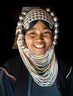 A woman from Akha tribal village wearing traditional headdress made of heavy silver A woman from Akha tribal village wearing traditional headdress made of heavy silver