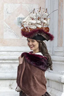 A woman wearing a hat decorated with an old sailing ship