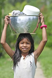 Young girl with a bucket on her head, Amacayon Indian Village, Amazon river, Puerto Young girl with a bucket on her head, Amacayon Indian Village, Amazon river, Puerto