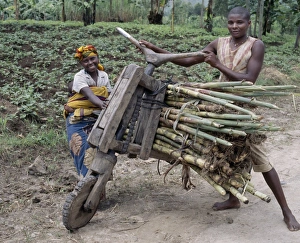 A young man and his wife push a homemade wooden bicycle A young man and his wife push a homemade wooden bicycle