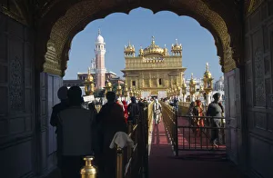 INDIA, Punjab, Amritsar Entrance arch to the Golden Temple with people walking along INDIA, Punjab, Amritsar Entrance arch to the Golden Temple with people walking along