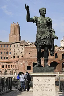 Italy, Lazio, Rome, Froi Imperiali, statue of Trajan with Trajan's market behind Italy, Lazio, Rome, Froi Imperiali, statue of Trajan with Trajan's market behind