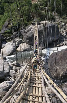 NEPAL, Annapurna Circuit Trek Crossing a sagging suspension bridge over the Khudi NEPAL, Annapurna Circuit Trek Crossing a sagging suspension bridge over the Khudi