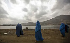 Afghan women clad in burqa walk along a road in Kabul Afghan women clad in burqa walk along a road in Kabul