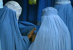 AFGHAN WOMEN PURCHASE BURQAS AT A ROADSIDE SHOP IN KABUL AFGHAN WOMEN PURCHASE BURQAS AT A ROADSIDE SHOP IN KABUL