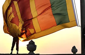 An air force officer holds the Sri Lanka national flag as the sun sets at galle face An air force officer holds the Sri Lanka national flag as the sun sets at galle face