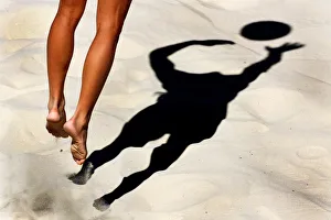 A BEACH VOLLEYBALL COMPETITOR SMASHES A BALL A BEACH VOLLEYBALL COMPETITOR SMASHES A BALL