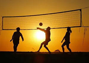 Images Dated 19th April 2013: Beachgoers play volleyball at the beach as the sun sets in Carlsbad, California