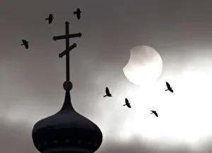 Birds fly past an Orthodox church during a partial solar eclipse in the town of Volozhin Birds fly past an Orthodox church during a partial solar eclipse in the town of Volozhin