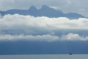 A boat sails on the Leman Lake in front of the misty Ai and Mayen mountains near Lausanne A boat sails on the Leman Lake in front of the misty Ai and Mayen mountains near Lausanne