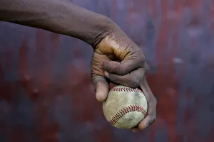 A boy holds on to a ball during a baseball training session in Haina A boy holds on to a ball during a baseball training session in Haina