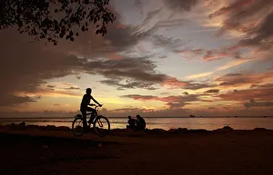 A boy rides a bicycle along a promenade in the evening in the southern Indian city A boy rides a bicycle along a promenade in the evening in the southern Indian city