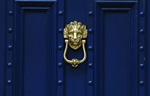 A brass door knocker is pictured on a blue door in London A brass door knocker is pictured on a blue door in London