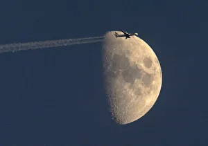 A British Airways passenger jet flies past the waxing moon over Zurich A British Airways passenger jet flies past the waxing moon over Zurich
