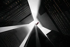 The Canadian flag is seen on top of a flagpole in the midst of high-rise buildings The Canadian flag is seen on top of a flagpole in the midst of high-rise buildings