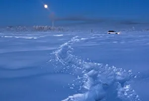 A car drives through the snow at night near Vostochnaya meteorological station A car drives through the snow at night near Vostochnaya meteorological station