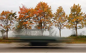 Car speeds alongside autumn trees near village of Zaslavl Car speeds alongside autumn trees near village of Zaslavl