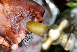 Nairobi Collection: A child prepares to drink clean water from a tap in Kawangware district of Nairobi