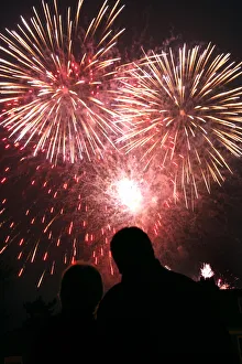 A couple watches fireworks explode over Kew Gardens in London A couple watches fireworks explode over Kew Gardens in London
