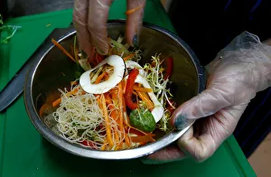 Employee prepares a salad in vegetarian restaurant Green Cuisine in Minsk Employee prepares a salad in vegetarian restaurant Green Cuisine in Minsk