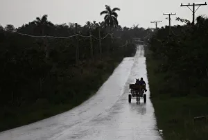A farmer rides in a horse-drawn cart as it rains on the outskirts of Havana A farmer rides in a horse-drawn cart as it rains on the outskirts of Havana