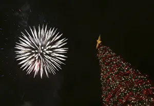 Fireworks light up the sky over a Christmas tree during a lighting ceremony at central Fireworks light up the sky over a Christmas tree during a lighting ceremony at central