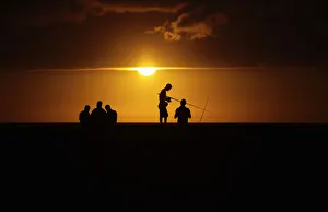 Fishermen stand on Havanas seafront boulevard El Malecon as the sun sets Fishermen stand on Havanas seafront boulevard El Malecon as the sun sets