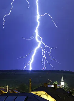 A fork of lightning strikes a mountain during a thunderstorm near the town of Barr south A fork of lightning strikes a mountain during a thunderstorm near the town of Barr south