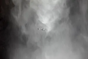 Helicopter with tourists onboard flies in front of Angel Falls also known as Salto Helicopter with tourists onboard flies in front of Angel Falls also known as Salto