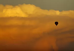 Images Dated 16th August 2014: A hot air balloon floats past a distant thunderstorm after sunset near San Diego