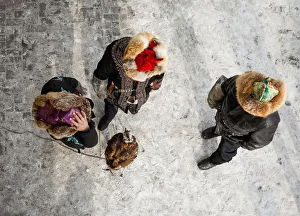 Hunters stay next to a tamed golden eagle during an annual competition at Almaty Hunters stay next to a tamed golden eagle during an annual competition at Almaty