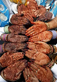 Indian women folk dancers show their hands decorated with henna paste before their Indian women folk dancers show their hands decorated with henna paste before their