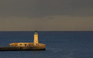 A lighthouse is seen at dusk in a harbour in Valletta A lighthouse is seen at dusk in a harbour in Valletta