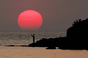 A local Thai man fishes at sunset near Patong Beach on the Thai resort island of Phuket A local Thai man fishes at sunset near Patong Beach on the Thai resort island of Phuket