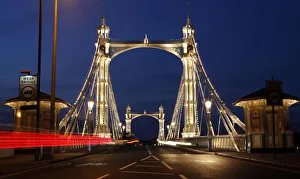 A London taxi crosses the Albert Bridge towards Chelsea from Battersea at sunset in A London taxi crosses the Albert Bridge towards Chelsea from Battersea at sunset in