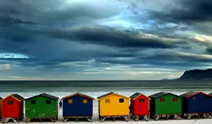 LONE STROLLER STANDS BY BEACH HUTS IN CAPE TOWN LONE STROLLER STANDS BY BEACH HUTS IN CAPE TOWN