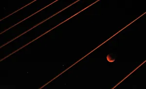 A lunar eclipse is visible among cables on the Anzac Bridge in Sydney A lunar eclipse is visible among cables on the Anzac Bridge in Sydney