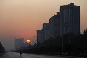 A man crosses a road as the sun sets in Islamabad A man crosses a road as the sun sets in Islamabad