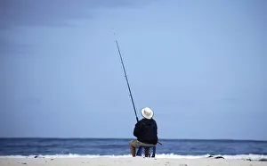 A man fishes at the beach at Bettys Bay near Kleinmond A man fishes at the beach at Bettys Bay near Kleinmond