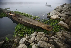 A man pushes his boat with the help of a bamboo stick to reach the bank of Rapti River at A man pushes his boat with the help of a bamboo stick to reach the bank of Rapti River at