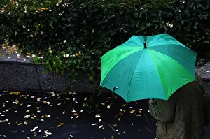 A man shelters from the rain underneath an umbrella in Madrid A man shelters from the rain underneath an umbrella in Madrid