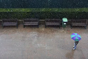 A man stands under an umbrella as rain stops play at the Wimbledon tennis championships A man stands under an umbrella as rain stops play at the Wimbledon tennis championships